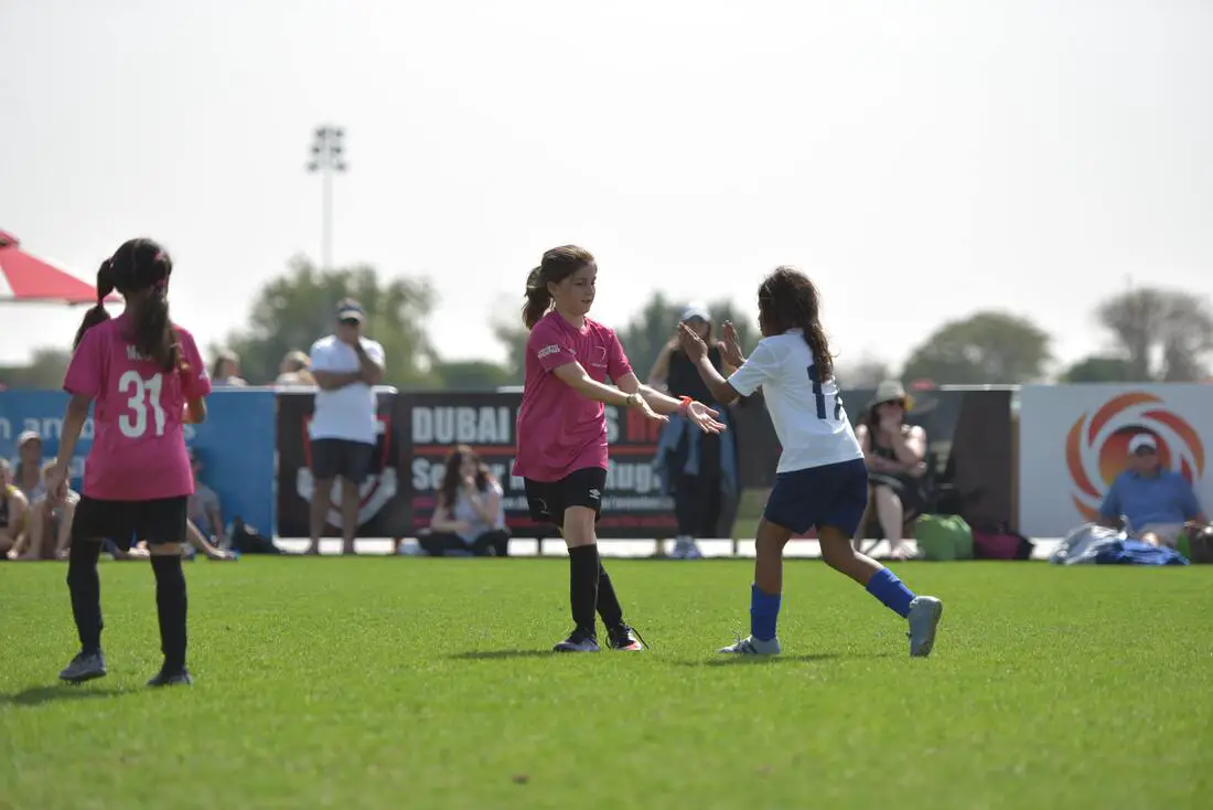 two young girls high fiving playing soccer