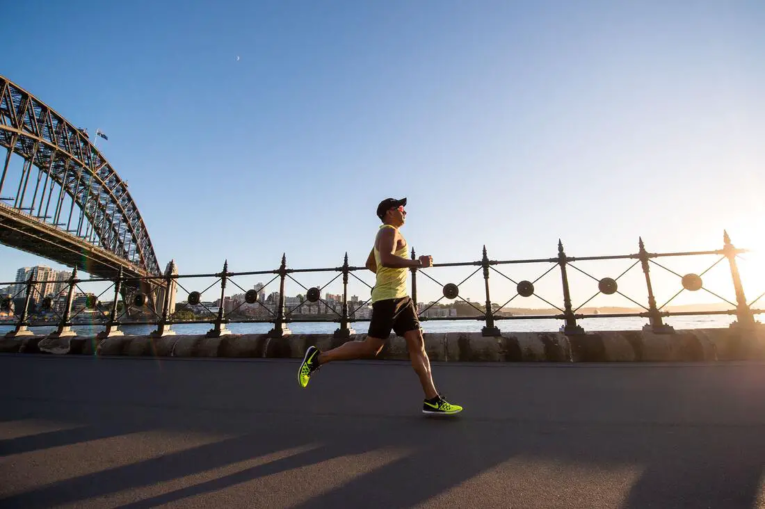 male distance runner running near a bridge