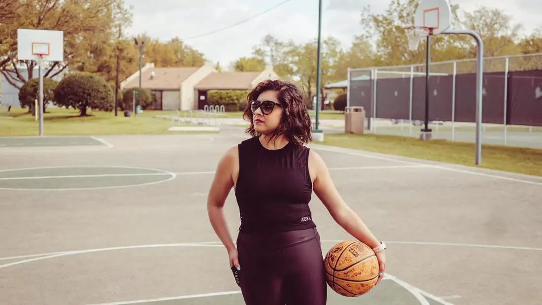 female basketball coaching holding a basketball at the playground
