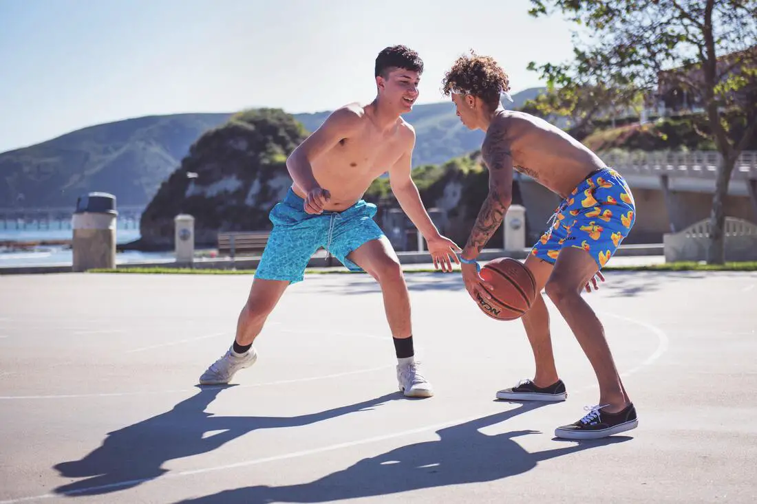 2 teenage boys having fun playing basketball outside